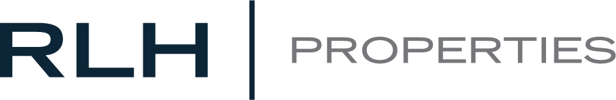 Logotipo de RLH Properties con "RLH" en letras negritas de color azul oscuro a la izquierda y "PROPERTIES" en letras grises a la derecha, separados por una línea vertical.